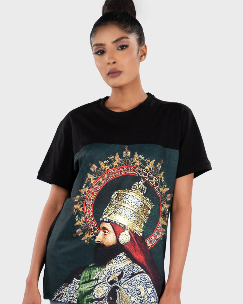 Front view of a woman wearing a black T-shirt with a front-panel print featuring a historic portrait of Emperor Haile Selassie I in ceremonial attire, framed by a decorative circular motif.